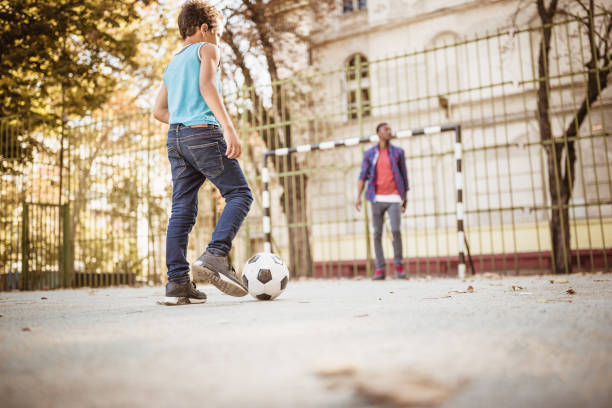 istock Father and son playing soccer 1398281194