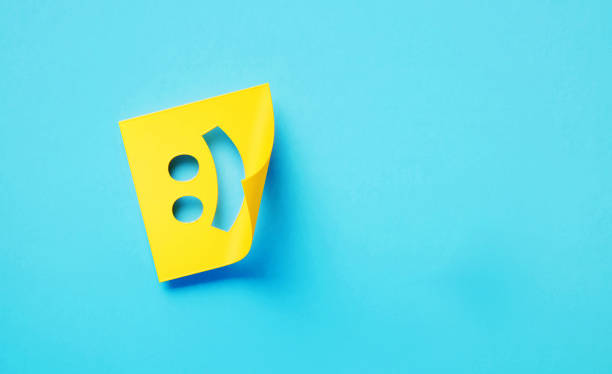 Cut Out Yellow Adhesive Note With Smiley Face Sitting Over Turquoise Background Cut out yellow adhesive note with smiley face sitting on turquoise background. Horizontal composition with copy space. smiley face postit stock pictures, royalty-free photos & images