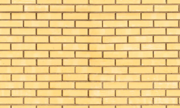 istock seamless background, yellow brick wall with cement mortar 1398286450