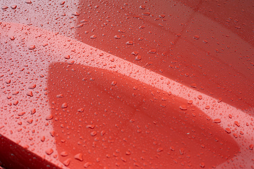 Raindrops on car. Red car is in details. Car is in rain.