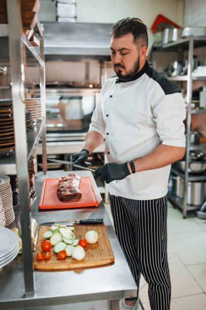 istock Man is making salad. Professional chef preparing food in the kitchen 1398287338