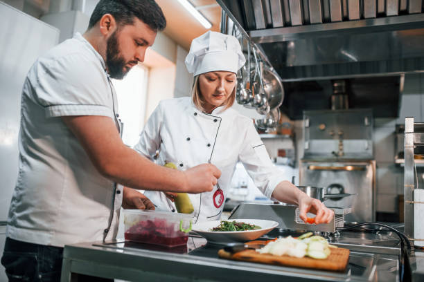 istock Three people. Making vegan salad. Professional chef preparing food in the kitchen 1398287363