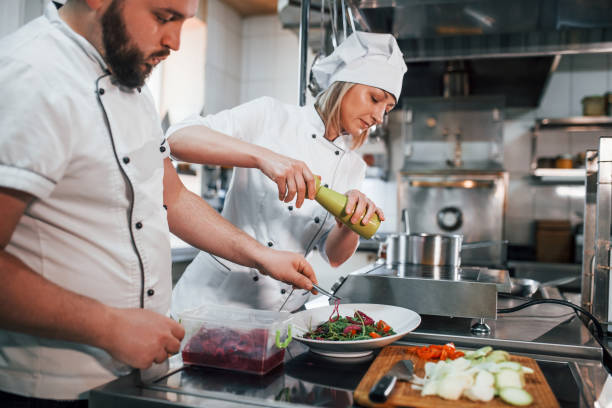 istock Three people. Making vegan salad. Professional chef preparing food in the kitchen 1398287369