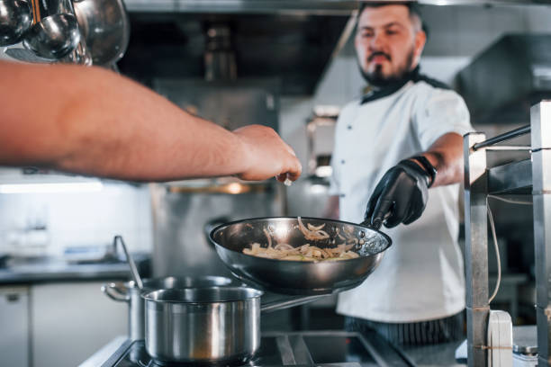 istock Pouring ingredients. Professional chef preparing food in the kitchen 1398287436