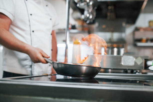 istock Method of cooking by igniting meal. Professional chef preparing food in the kitchen 1398287482