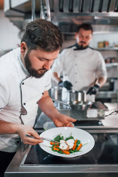 istock Two brothers is making salad. Professional chef preparing food in the kitchen 1398287583