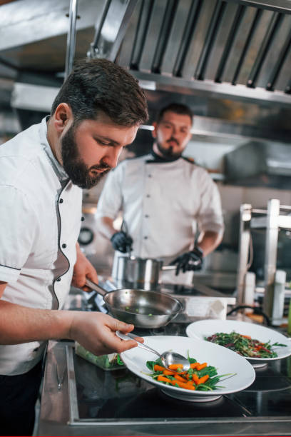 istock Two brothers is making salad. Professional chef preparing food in the kitchen 1398287585