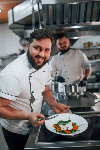 istock Two brothers is making salad. Professional chef preparing food in the kitchen 1398287599