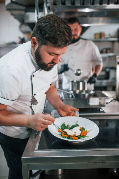 istock Two brothers is making salad. Professional chef preparing food in the kitchen 1398287616