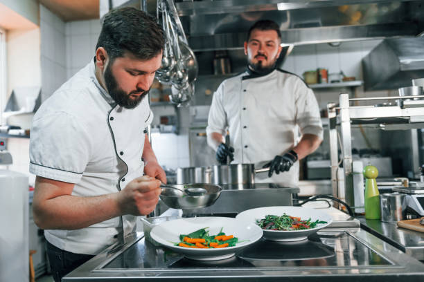 istock Two men is making salad. Professional chef preparing food in the kitchen 1398287659