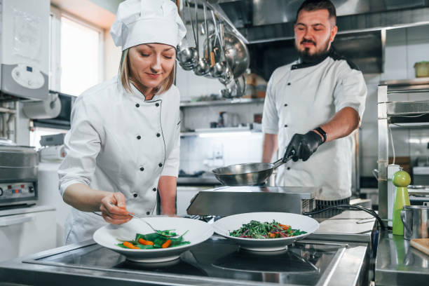 istock Working together. Professional chef preparing food in the kitchen 1398287660