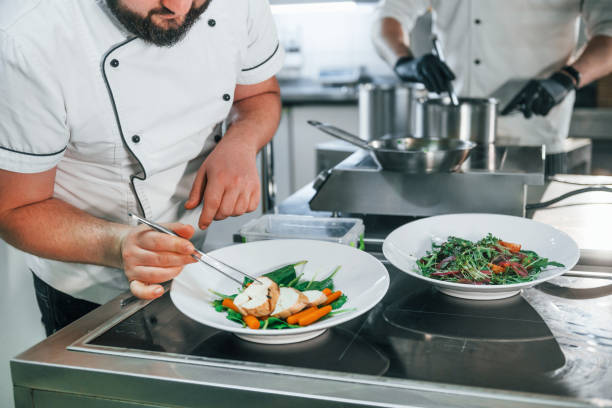 istock Two men is making salad. Professional chef preparing food in the kitchen 1398287678