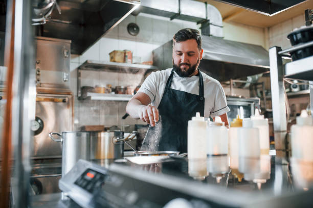 istock Pouring some salt. Professional chef preparing food in the kitchen 1398287786