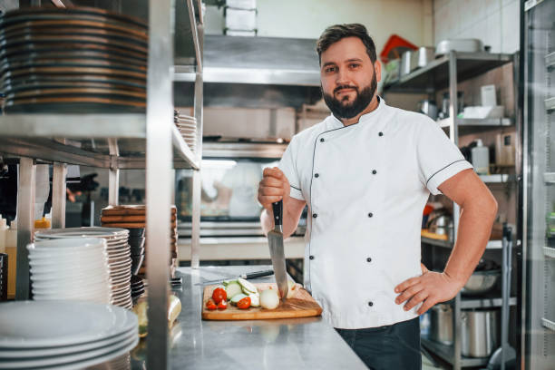 istock Man is making salad. Professional chef preparing food in the kitchen 1398287798