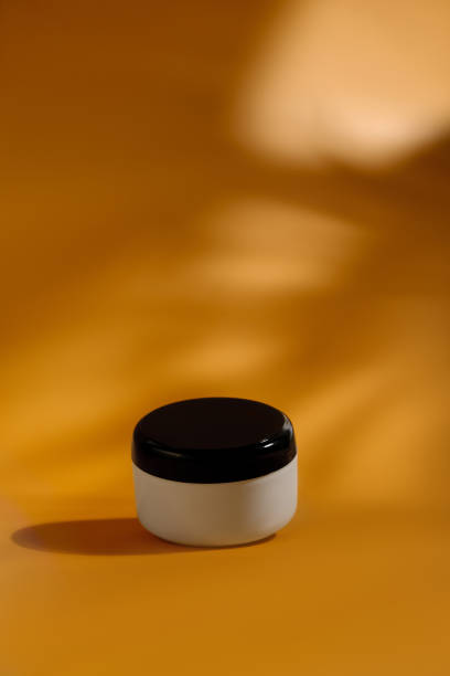 istock Moisturizing cream jar on orange background. Cosmetic container mock up. 1398289824