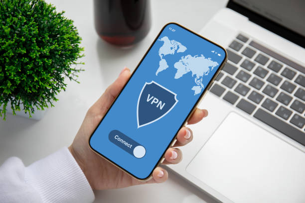 istock female hand holding phone with app vpn over table laptop 1398290269
