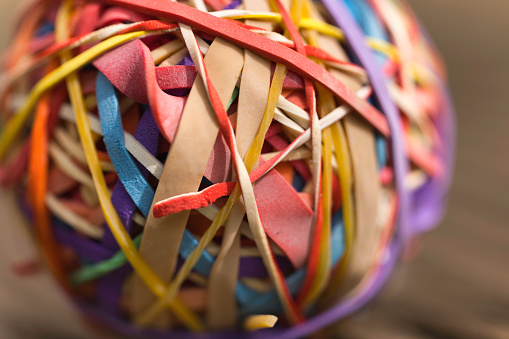 Large ball of elastic bands, collected over many years and beginning to perish.