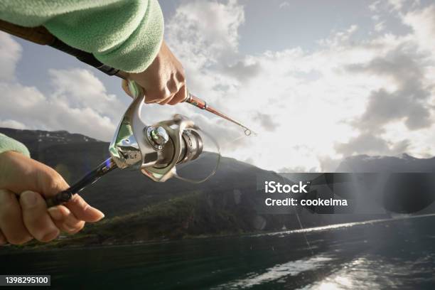 Woman Fishing On Fishing Rod Spinning In Norway Stock Photo - Download  Image Now - Activity, Adult, Blue - iStock