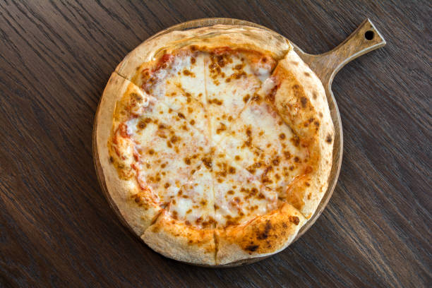 istock Fresh four cheese pizza sliced on wooden table 1398295482