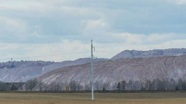 istock Mountains of empty ore when mining potassium on cloudy sky background. Transportation of an empty rock to a dump. 1398296364