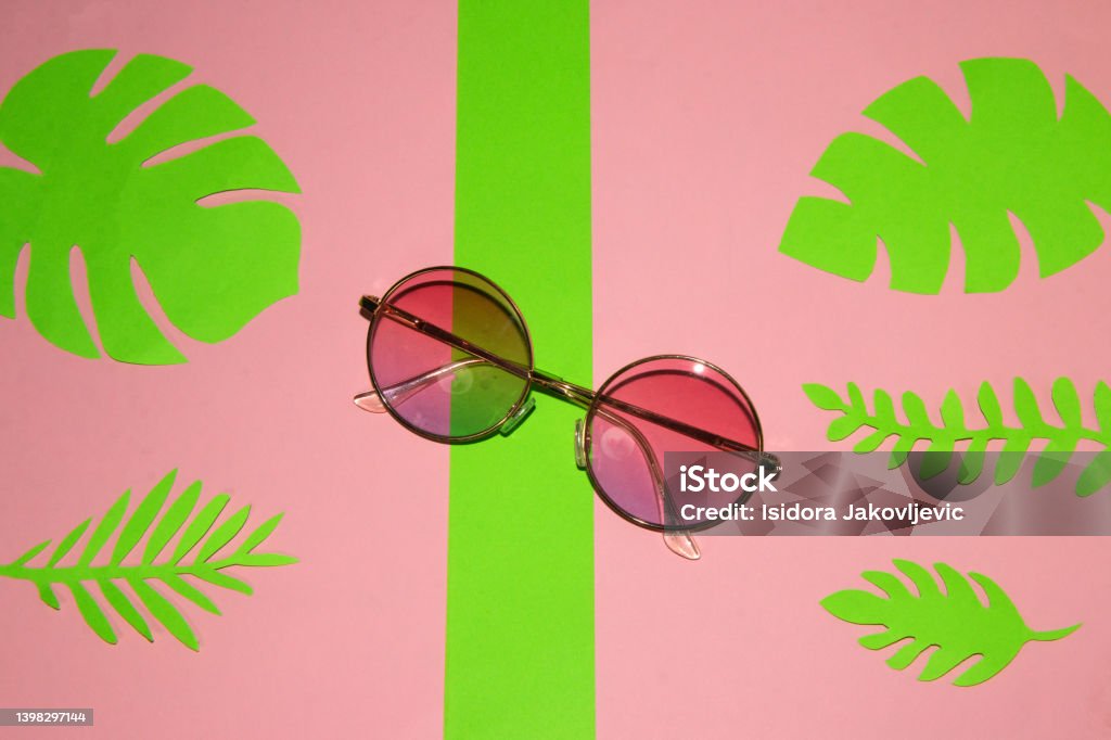 napszemüveg rózsaszín-zöld háttérrel, zöld levelekkel, kreatív trópusi kialakítással - Jogdíjmentes Csendes-óceáni szigettérség témájú stock fotó napszemüveg rózsaszín-zöld háttérrel, zöld levelekkel, kreatív trópusi kialakítással - Jogdíjmentes Csendes-óceáni szigettérség témájú stock fotó
