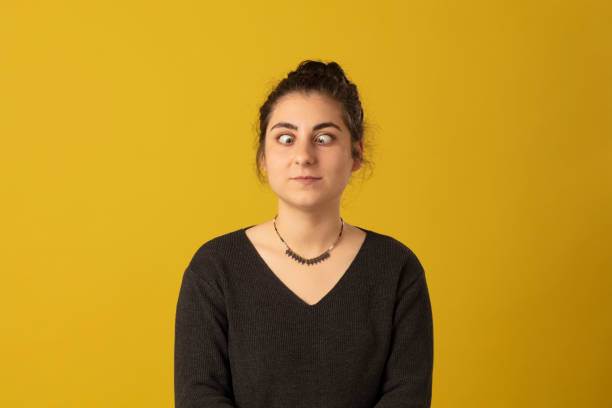 Photo portrait of Squint woman wearing striped t-shirt on yellow background stock photo