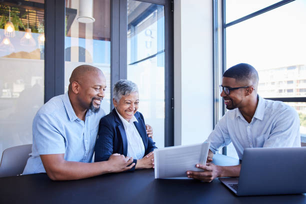 istock Smiling mature couple reading documents with their financial advisor in his office 1398301161