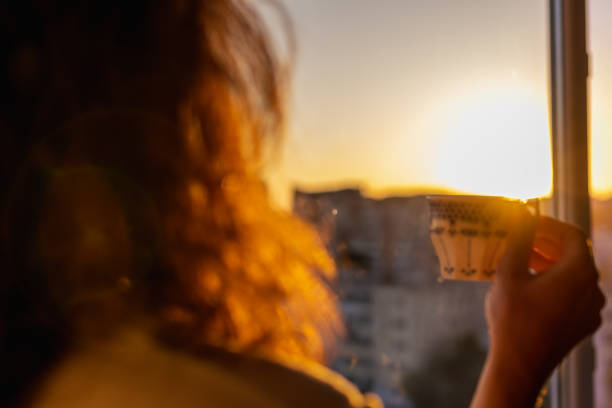 Watching the sunrise holding the coffee cup