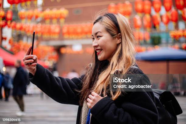 Young Asian Woman Using Phone At Chinatown Stock Photo - Download Image Now - Chinatown, London - England, Adult
