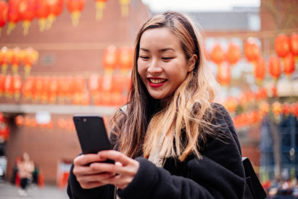 Young Asian Woman using phone at Chinatown Young Asian Woman using phone at Chinatown snapschat stock pictures, royalty-free photos & images