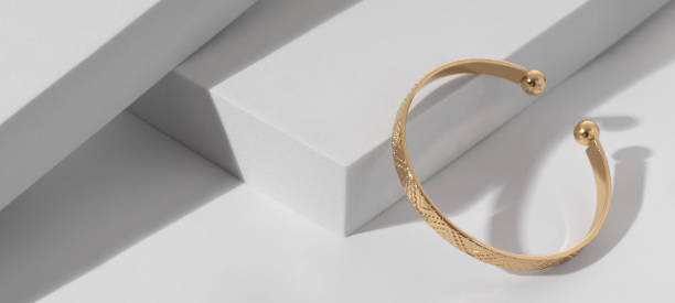 istock Panoramic shot of a Modern gold bracelet with geometric pattern on minimalistic white background 1398306292