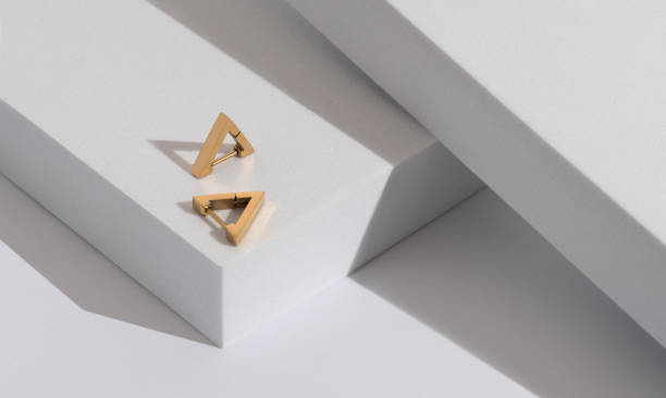 istock Top view of Triangle modern earrings pair on minimal geometric white background with copy space 1398306461