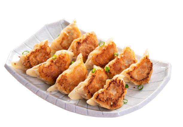 istock Pan-fried gyoza dumpling jiaozi in a plate isolated on white background. 1398306569