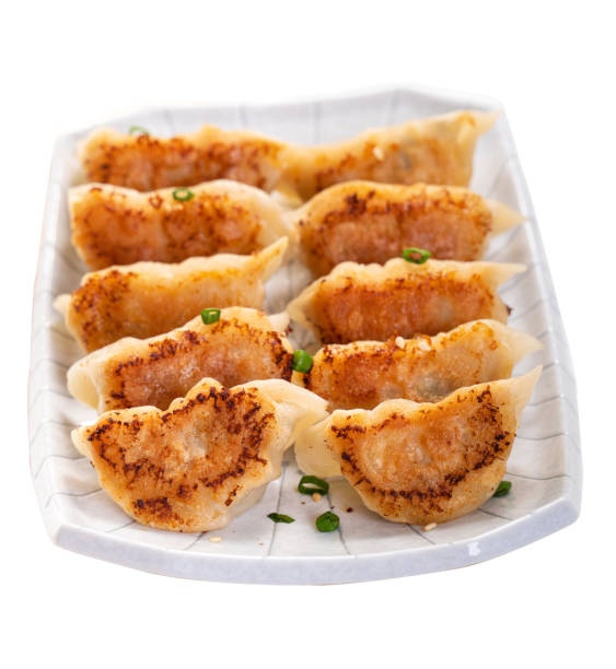 istock Pan-fried gyoza dumpling jiaozi in a plate isolated on white background. 1398306599