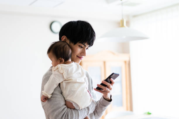 스마트폰으로 육아를 연구하는 한 남자 - 육아 뉴스 사진 이미지