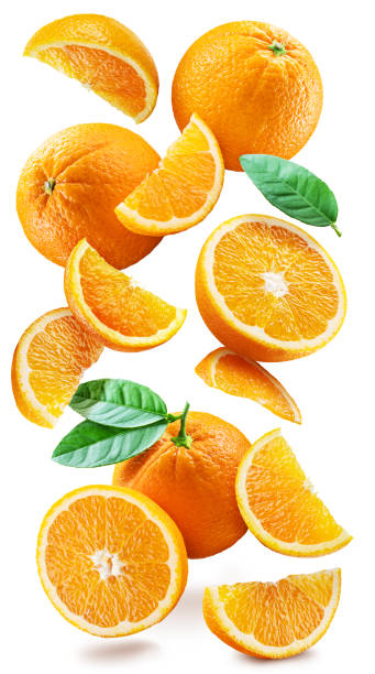 istock Ripe oranges with halves and slices with orange tree leaves randomly fall or levitate on a white background. Juicy background for your project. Clipping path. 1398312629
