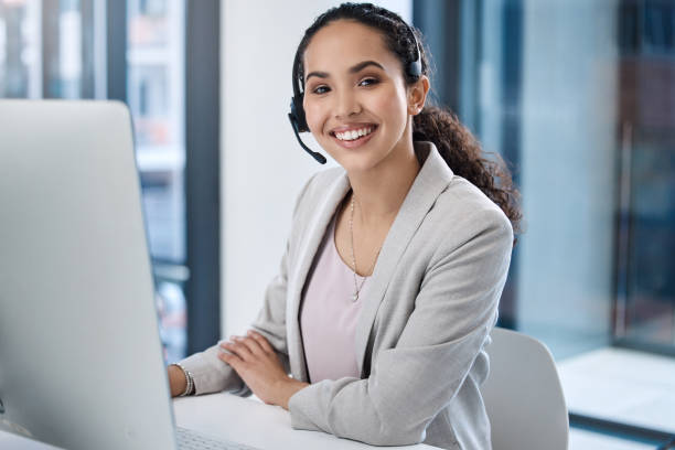 istock Portrait of smiling mixed race call center agent using a computer in an office. Hispanic customer care assistant wearing headset and answering calls from clients. Ambitious salesperson calling customer 1398313381