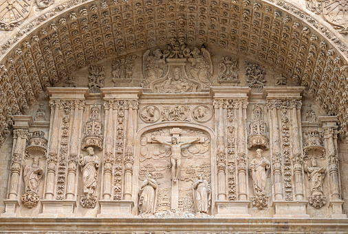 Hermoso bajorelieve en piedra con escena de la crucifixión de Jesucristo en el tímpano de la fachada del monasterio san Esteban de Salamanca, España photo