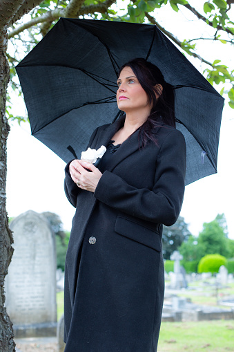 A grieving widow at a churchyard.