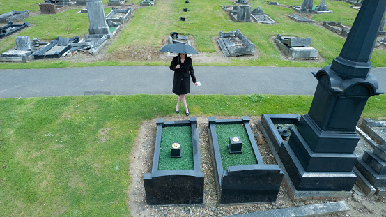 A grieving widow at a churchyard.