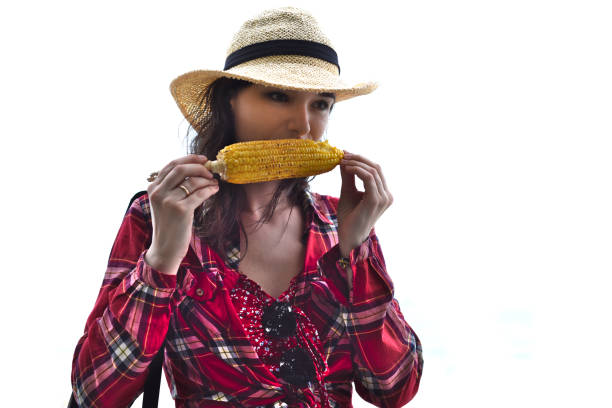 istock Young woman in hat eating grilled corn against white background 1398316031