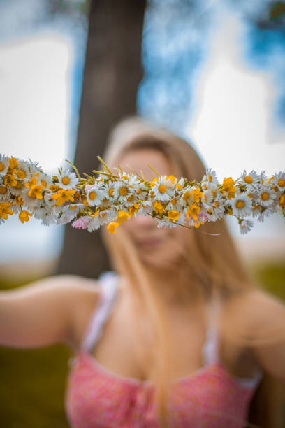 Young beautiful girl covering her eyes with flowers