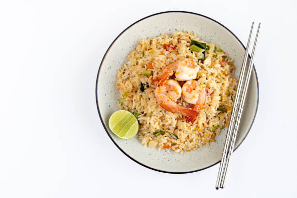 istock Thai fried rice with shrimp, egg, tomato, green onion, lime and chopsticks on a white background, top view. Thai food top view. 1398317281
