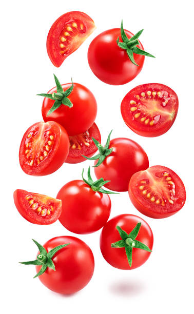 istock Falling cherry tomatoes and tomato slices isolated on white background. Macro shot. File contains clipping paths for each item. 1398317719
