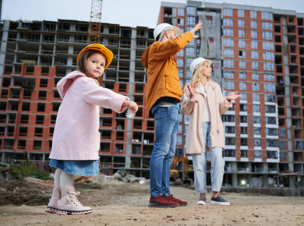 istock Child with parents standing outdoors at construction site. 1398317893