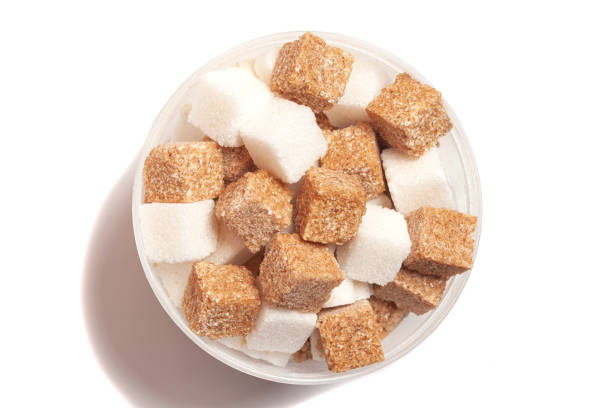 istock Cube of brown and white sugar in a plastic box isolated on white background, top view 1398319368
