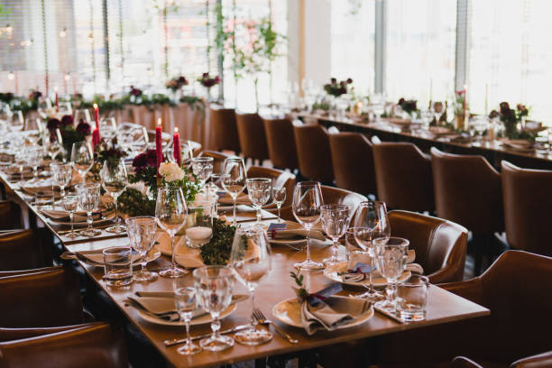 istock Table setting at the wedding reception. Floral compositions with beautiful ranunculus flowers and greenery, candles, laying and plates on a decorated table. 1398322057