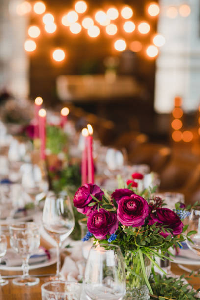 istock Table setting at the wedding reception. Floral compositions with beautiful ranunculus flowers and greenery, candles, laying and plates on a decorated table. 1398322058