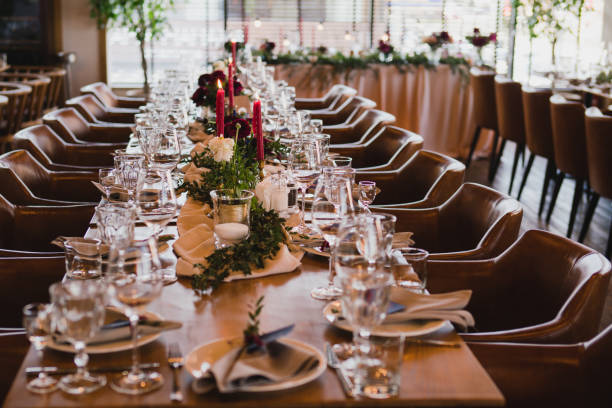 istock Table setting at the wedding reception. Floral compositions with beautiful ranunculus flowers and greenery, candles, laying and plates on a decorated table. 1398322066