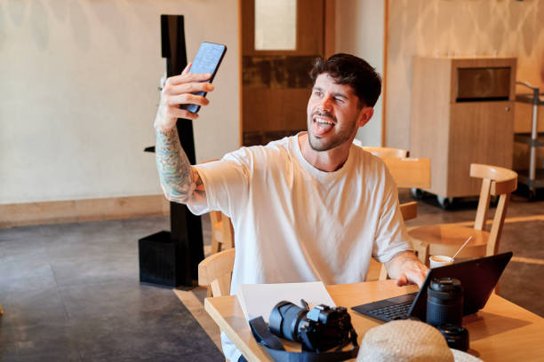 istock Man takes a self-portrait in a coffee shop while he is smiling 1398323526